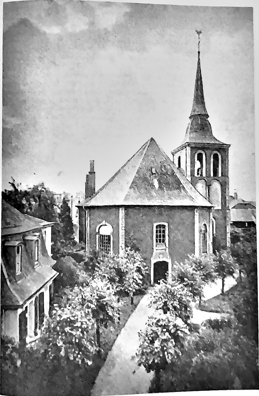 Die evangelische Kirche Odenkirchen von 1757 mit hohem Glockenturm und barocker Haube, links das Pfarrhaus